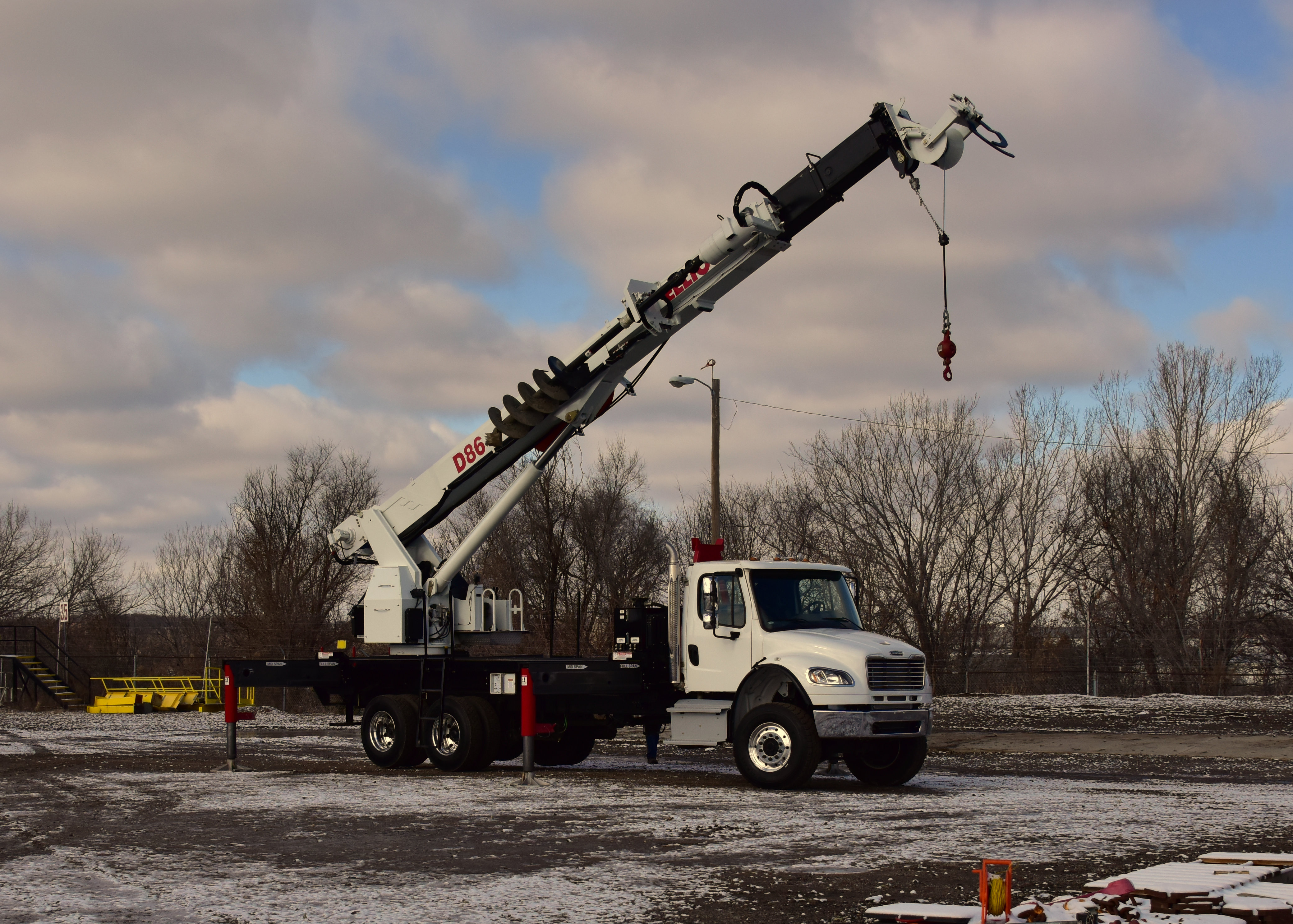Elliott digger derrick truck crane in lot with snow on the ground