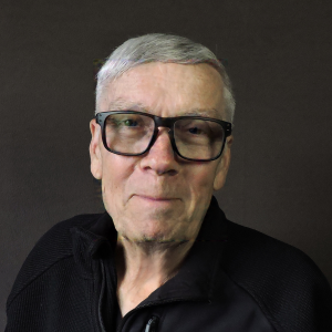 Ray Smith smiling in a black zip up shirt